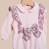 Tutina con colletto di ciniglia rosa con rouches laterali e fiocco floreale