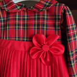 Abito velluto rosso con gonna plissettata in tartan e fiore sul lato