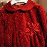 Abito di velluto rosso con pois bianchi e fiore sul lato